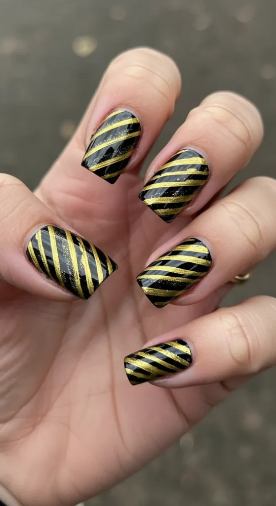 Bold black or gold stripes crisscrossing each nail, with varying angles and widths for a dynamic, stylish look. ✨

