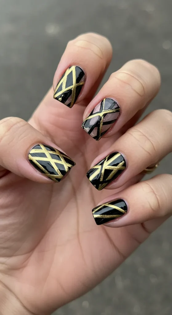 Bold black or gold stripes crisscrossing each nail, with varying angles and widths for a dynamic, stylish look. ✨

