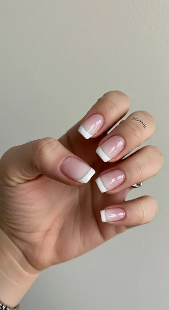 A soft and elegant gradient manicure fading from pink to white, creating a smooth and delicate ombre effect for a fresh, feminine look.