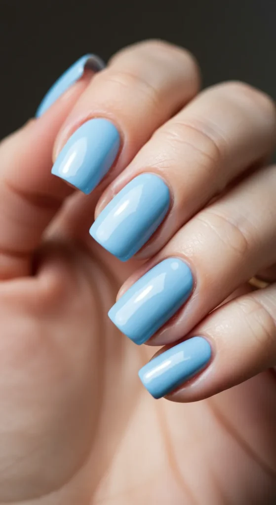 Nails painted in a soft sky blue with a smooth, glossy finish, exuding a calm and serene vibe.

