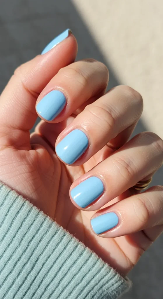 Nails painted in a soft sky blue with a smooth, glossy finish, exuding a calm and serene vibe.

