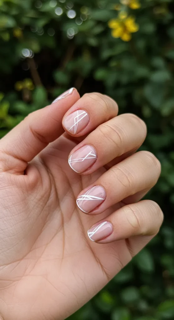 A stylish set of Soft Nude and White Geometric Nails featuring clean lines and modern geometric patterns for a chic and minimalist look.